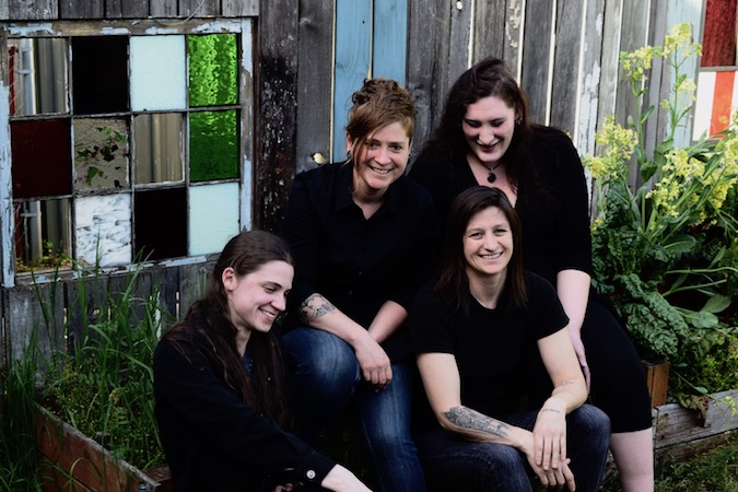 Group of women in black t-shirts sitting on steps together